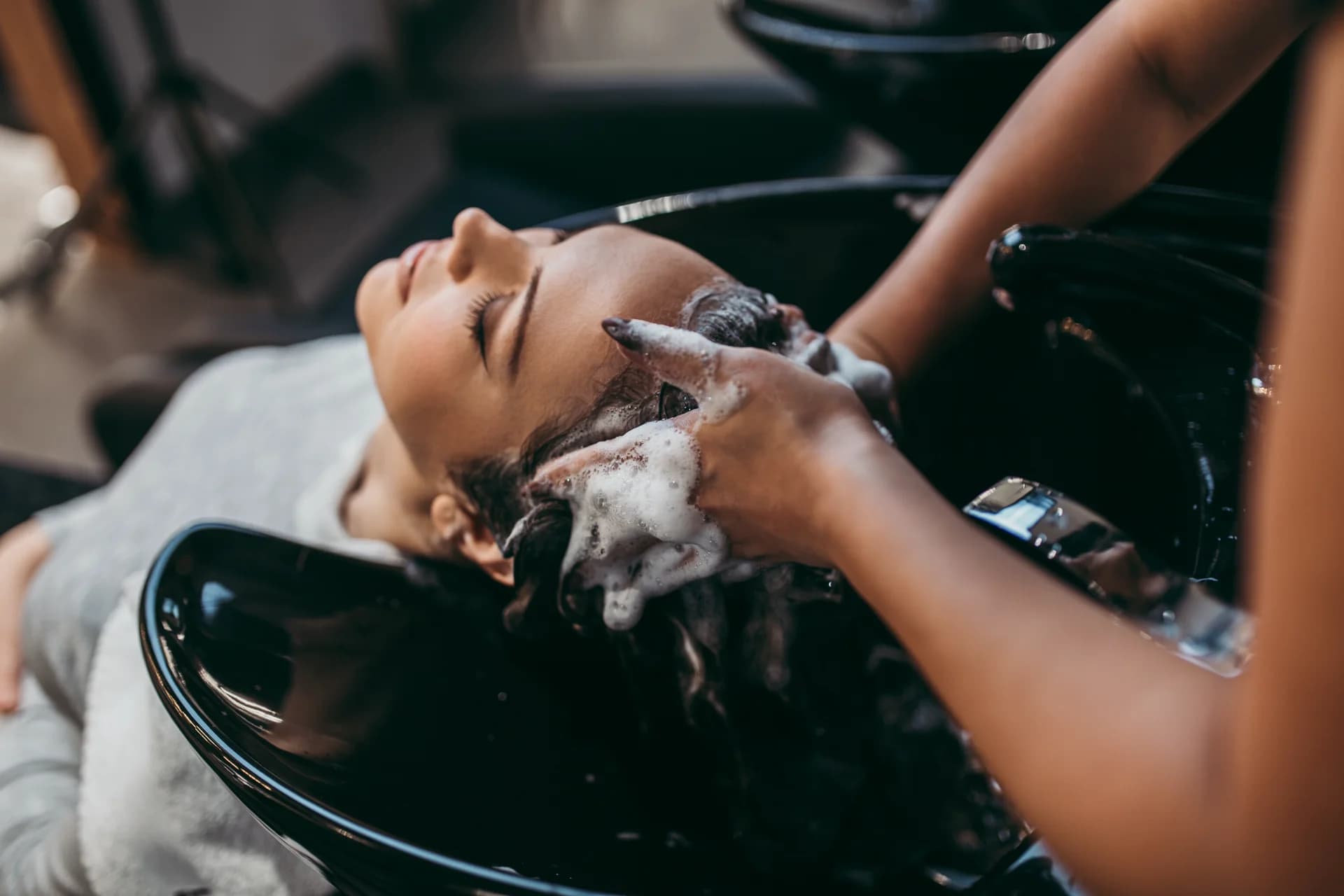 A client relaxing during a salon hair wash in Spokane