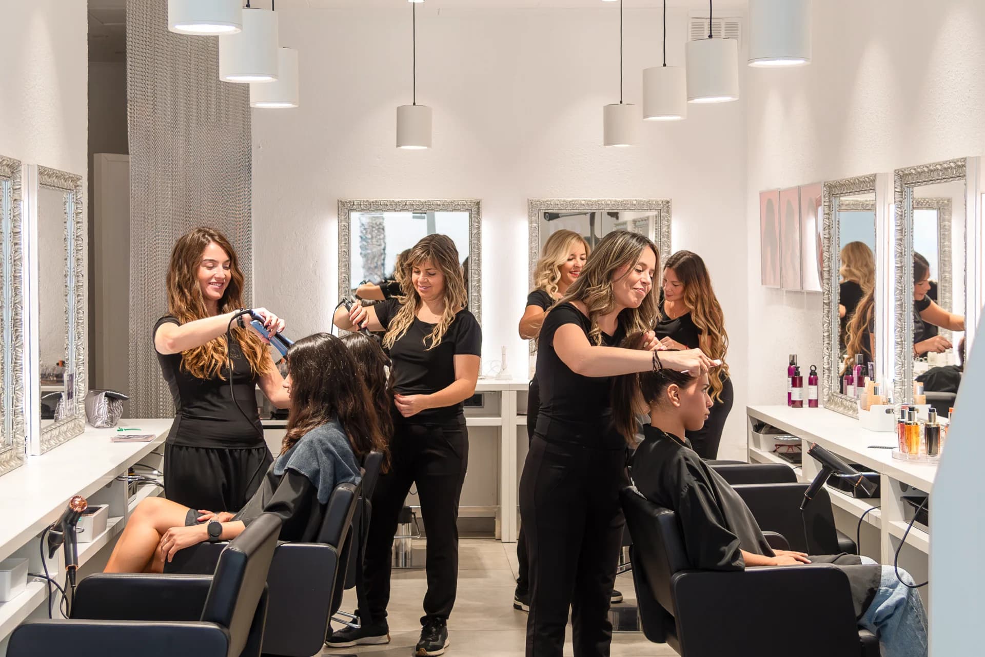 A team of Spokane stylists working with clients on a bright salon floor